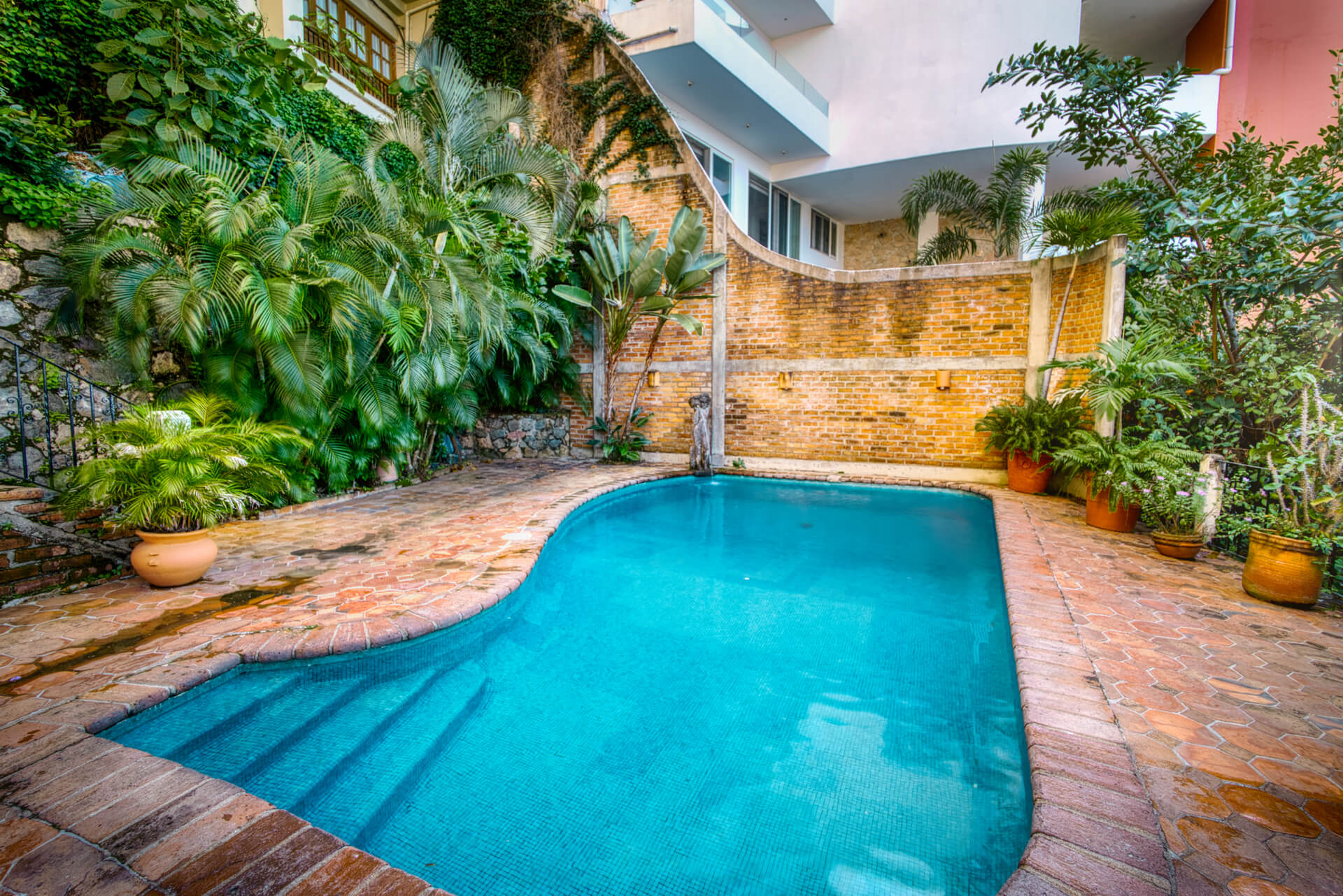 condo pool surrounded by lush plants